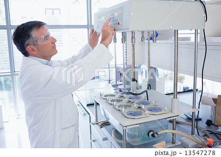 Scientist with safety glasses using the machine Scientist with safety glasses using the machine 13547278