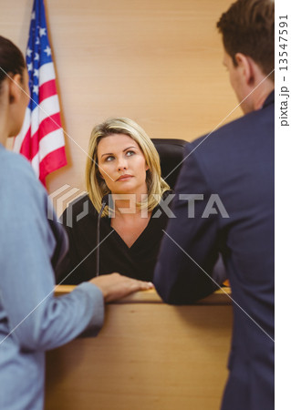 Judge and lawyers speaking in front of the american flag 13547591