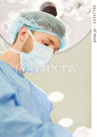 Young surgeon wearing mask and cap 13547795