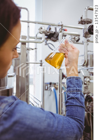 Stylish girl in denim jacket holding beaker of beer 13547923