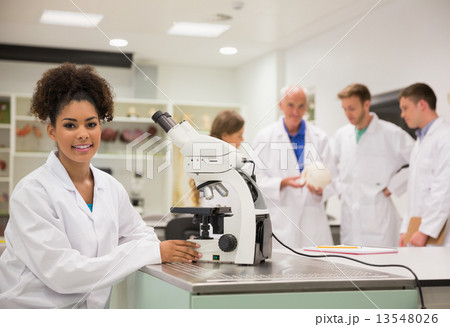 Happy medical student working with microscope Happy medical student working with microscope 13548026