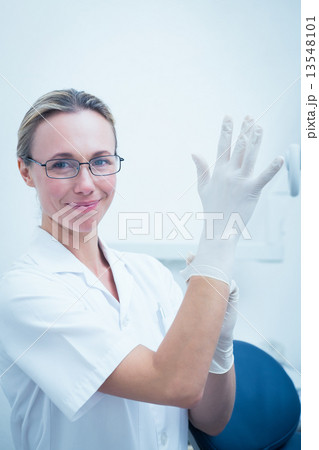 Female dentist wearing surgical glove 13548101
