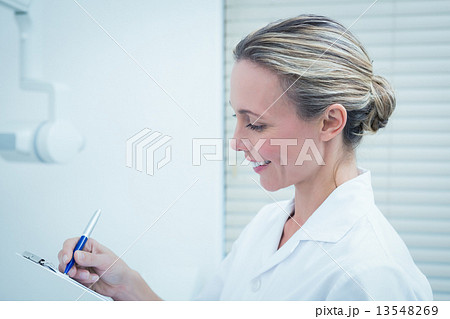 Female dentist checking reports Female dentist checking reports 13548269