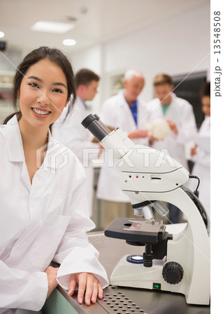 Young medical student working with microscope Young medical student working with microscope 13548508