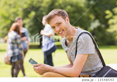 Handsome student studying outside on campus Handsome student studying outside on campus 13548543