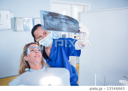 Dentist explaining x-ray to patient Dentist explaining x-ray to patient 13548663