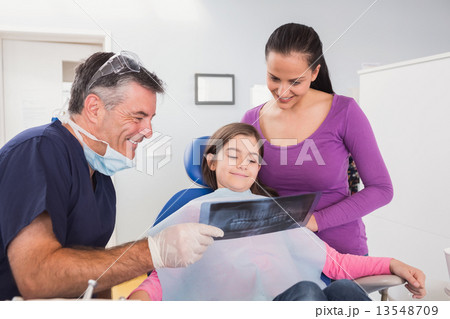 Pediatric dentist explaining to mother and her daughter the x-ra Pediatric dentist explaining to mother and her daughter the x-ra 13548709