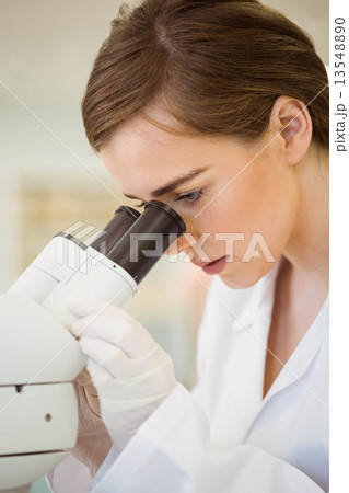 Young scientist working with microscope 13548890