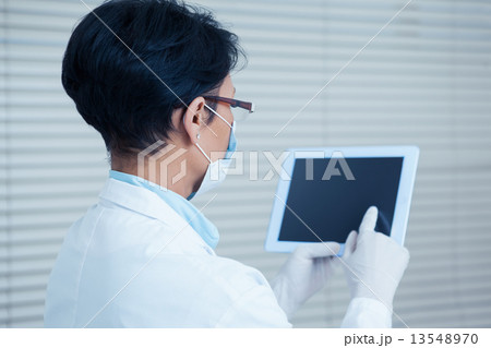 Female dentist using digital tablet 13548970
