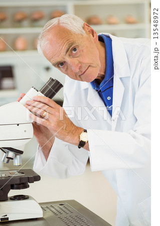 Senior scientist working with microscope 13548972