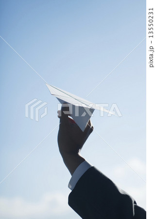 紙飛行機を持つビジネスマンの手 13550231