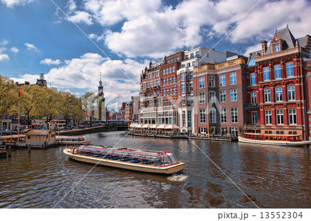 Amsterdam city with boats on canal  in Holland 13552304