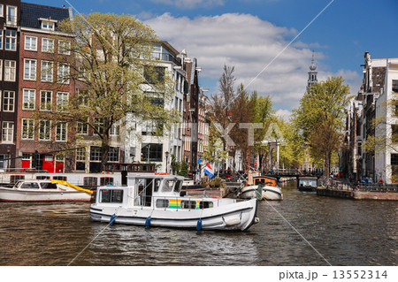 Amsterdam city with boats on canal in Holland Amsterdam city with boats on canal in Holland 13552314