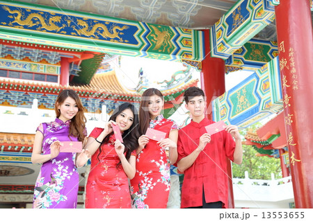 Man woman in Cheongsam holding Chinese New Year Gift Envelops at Temple Man woman in Cheongsam holding Chinese New Year Gift Envelops at Temple 13553655