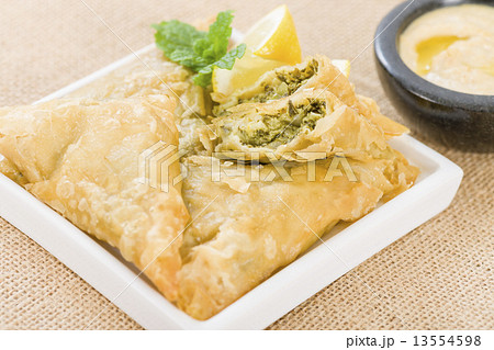 Borek - Middle Eastern spinach and cheese stuffed pastry served with hummus and lemon wedges. 13554598