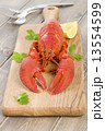 Lobster and lemon wedges on a chopping board.  13554599