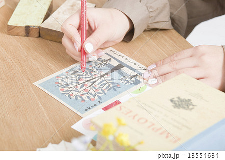 雑貨と絵はがきを書く女性 13554634