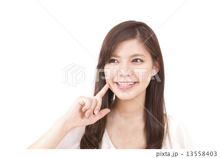 頬を触る若い女性 13558403