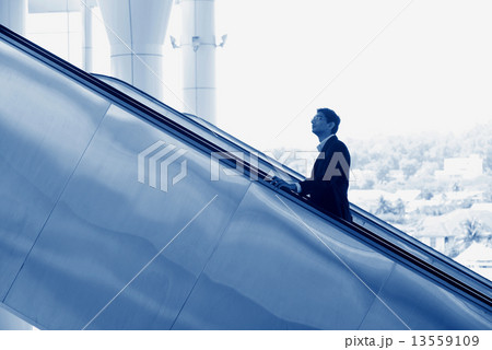 Indian businessman going up escalator 13559109