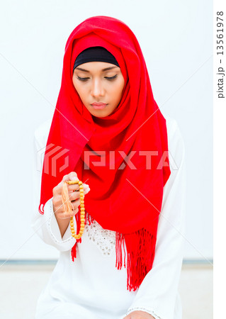 Asian Muslim woman praying with beads chain 13561978
