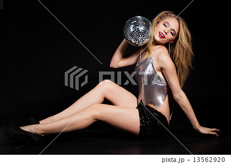 Fashion girl with disco ball over black background 13562920