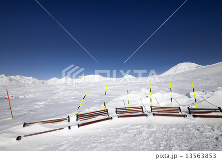 Ski slope and wooden benches in snow 13563853