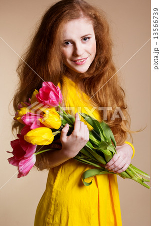 Beautiful redheared girl with bouquet of tulips 13566739