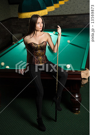 sexy girl in corset plays billiards. 13569873