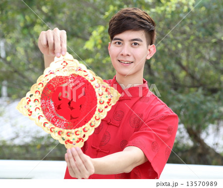 Man in Chinese Cheongsam holding Chinese New Year sign Focus on Face 13570989