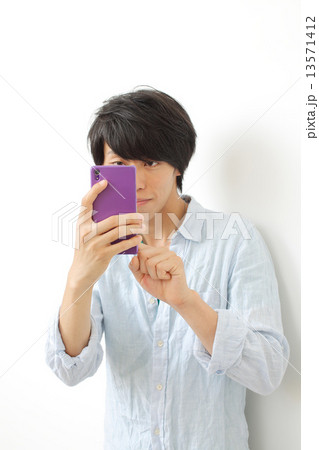 スマホで撮影する20代男性 13571412