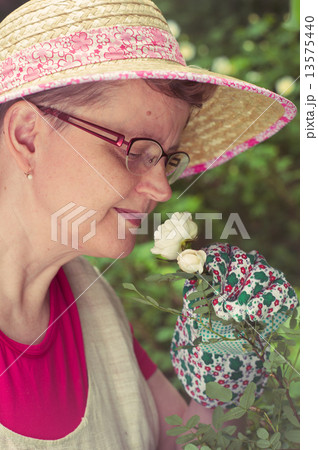 Mature woman and white rose 13575440