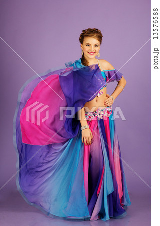Beautiful belly dancer wearing a purple costume Beautiful belly dancer wearing a purple costume 13576588