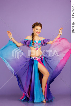 Beautiful belly dancer wearing a purple costume Beautiful belly dancer wearing a purple costume 13576642