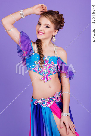 Beautiful belly dancer wearing a purple costume Beautiful belly dancer wearing a purple costume 13576644