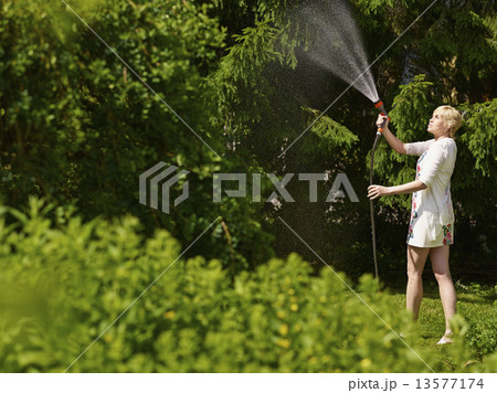 Woman and garden hose 13577174