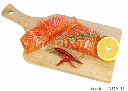 raw salmon steak with lemon and spices on a cutting board 13579151
