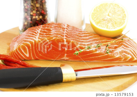 raw salmon steak with lemon and spices on a cutting board 13579153