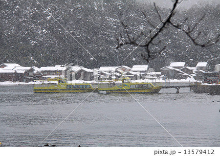 雪景色の伊根の舟屋群と伊根湾めぐり遊覧船「国指定重要伝統的建造物群保存地区」 13579412