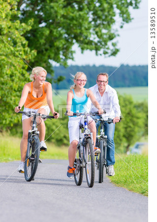 Family having weekend bicycle tour outdoors Family having weekend bicycle tour outdoors 13589510