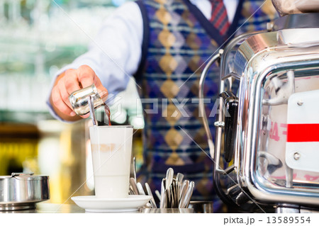 Barista in cafe pouring espresso shot in latte macchiato 13589554