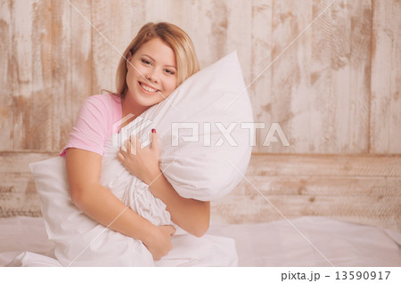 Young woman hugging the pillow Young woman hugging the pillow 13590917