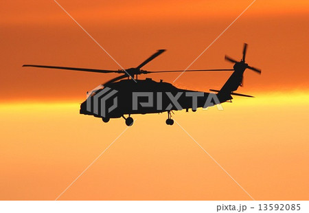 鮮やかな夕焼けを背景に飛行中の米海軍ＳＨ－６０Ｂシーホーク艦上対潜ヘリコプター 13592085