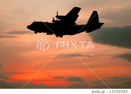 鮮やかな夕焼けを背景に飛行中の米海軍Ｃ－１３０Ｔハーキュリーズ輸送機 13592093
