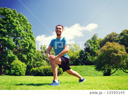 smiling man stretching outdoors 13593145