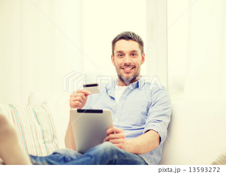smiling man working with tablet pc at home smiling man working with tablet pc at home 13593272