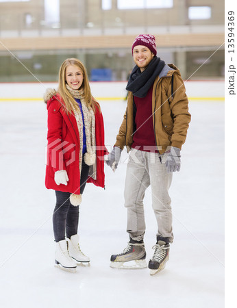 happy couple holding hands on skating rink 13594369