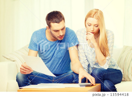 busy couple with papers and calculator at home 13594418