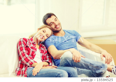 smiling couple relaxing on sofa in new home smiling couple relaxing on sofa in new home 13594525