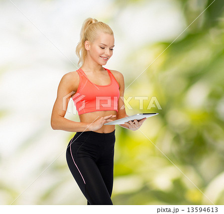 smiling sporty woman with tablet pc computer 13594613