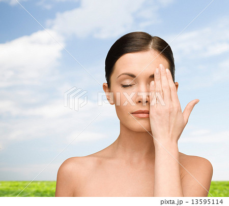 smiling young woman covering face with hand 13595114